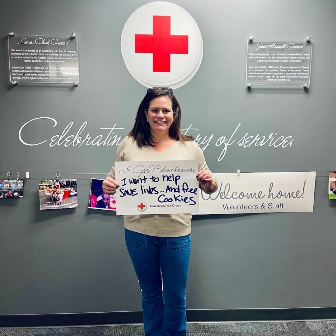 blood donor holding up sign on why she donates blood