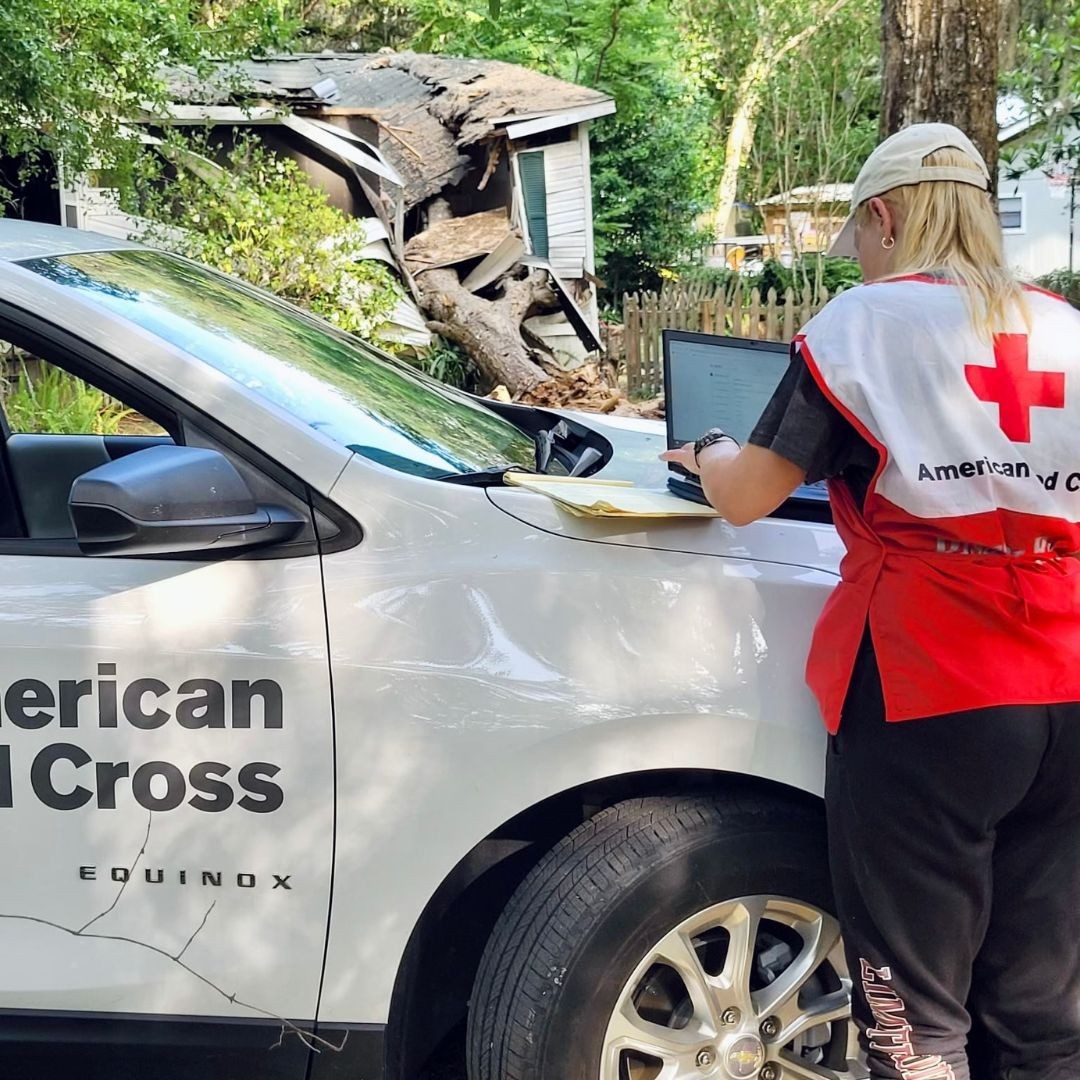 volunteer taking notes of disaster damages outside