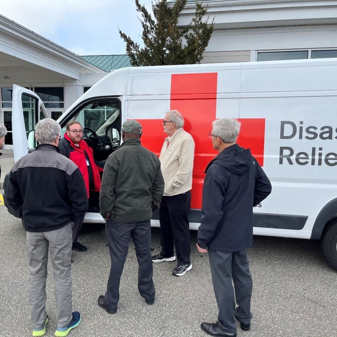 red cross volunteers in front of emergency response vehicle