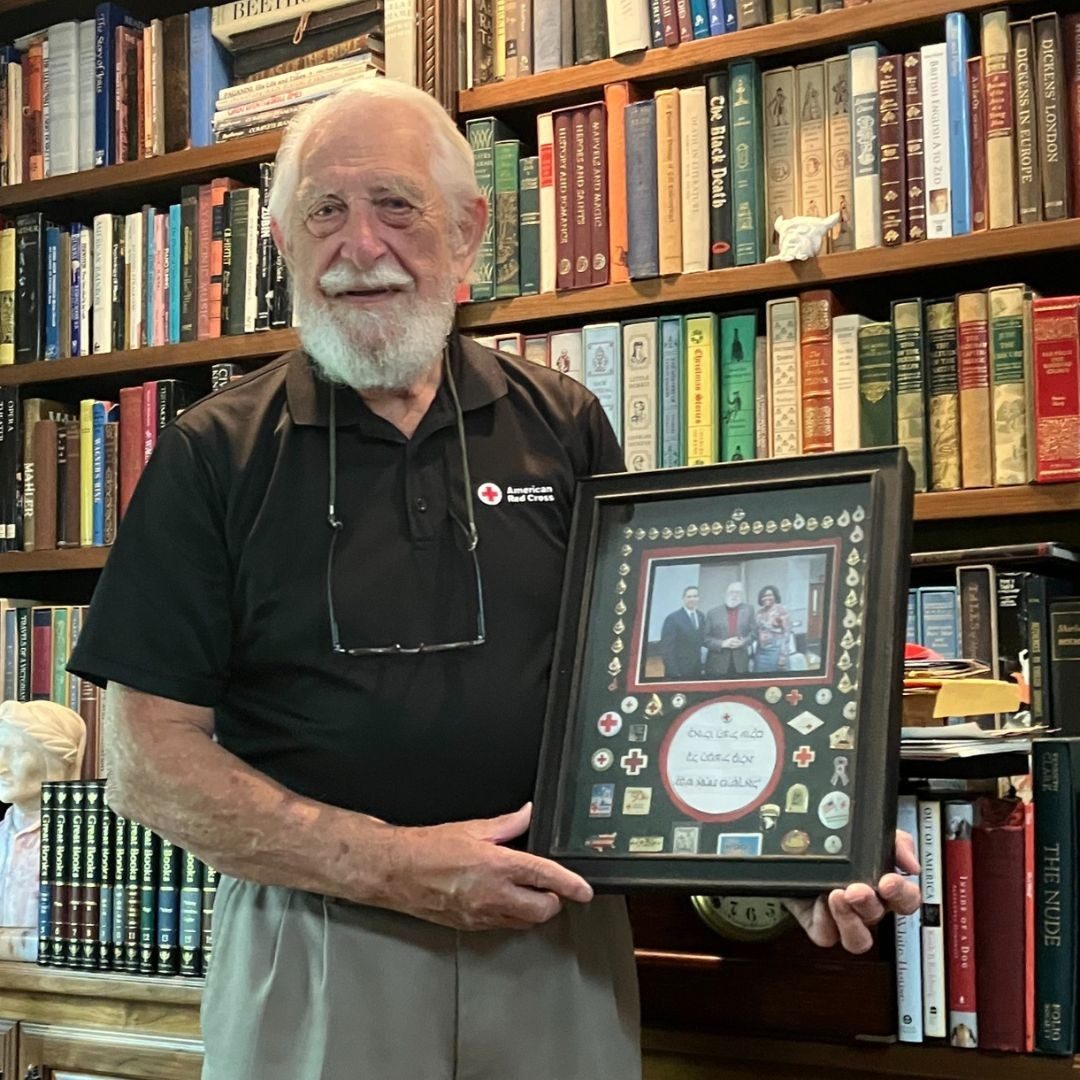 ray swadley holding frame of his honors throughout the years