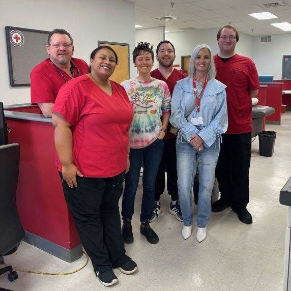 Red Cross blood donation center staff and Ashley Corsolini group photo inside Red Cross blood donation center building.