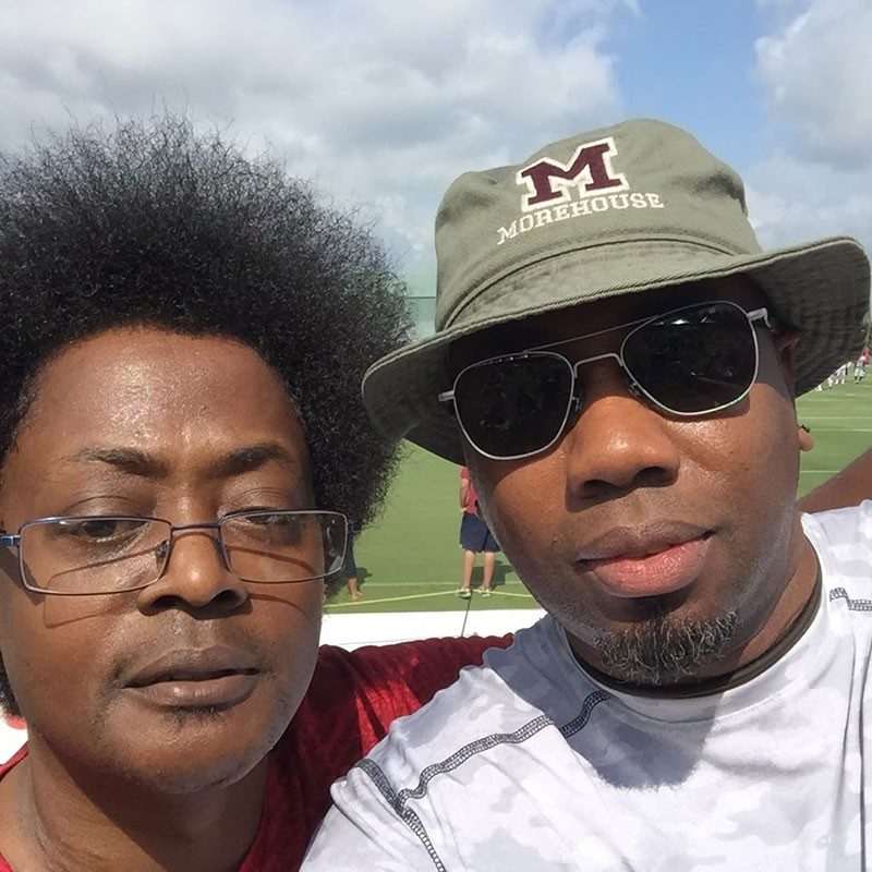 Two people, one wearing glassesand the other with a hat and sunglasses, take a selfie.