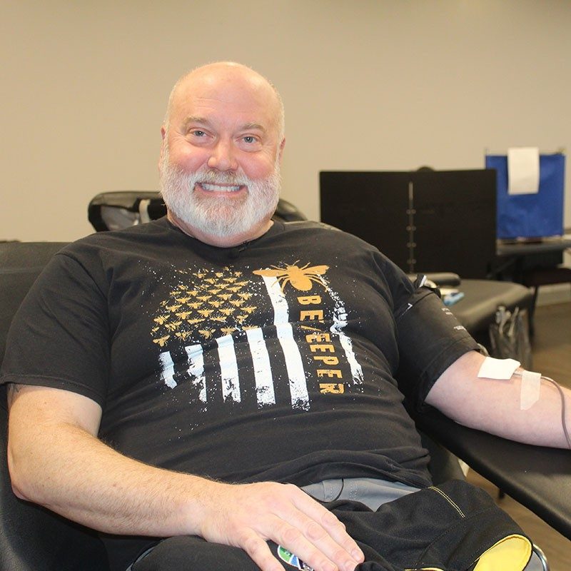 Red Cross worker and volunteer, Mark Fleischer smiling while donating blood.