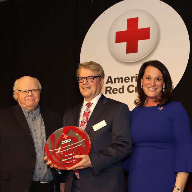 Richard Burke holding The H. Peter Burg Community Leader Award at the 2024 Acts of Courage Awards event.