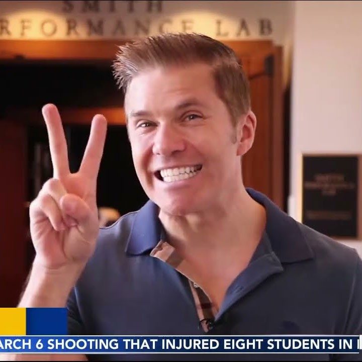 Adam Joseph smiling and giving a peace sign with his hand.