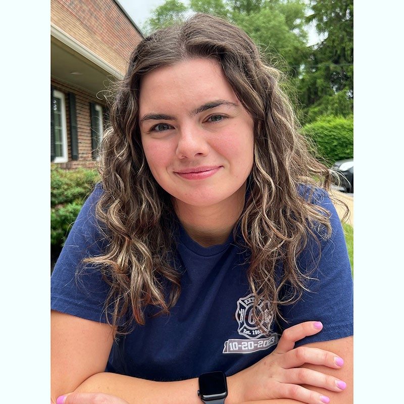 Emily Gindele outside the Colin Reedy Memorial Blood Drive wearing a Firefighter t-shirt.