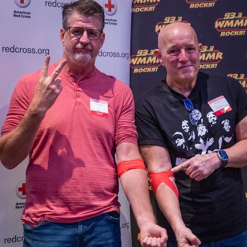 Preston Elliot and Steve Morrison with red bandage around arm after donating blood.