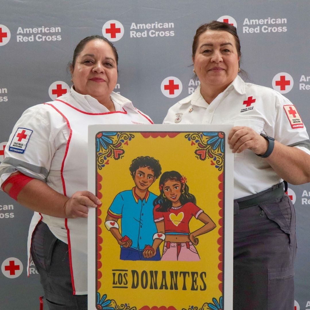 red crossers holding los donantes signage