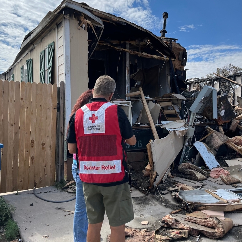 Jamilah holding up Metallica shirt smiling after donating blood.