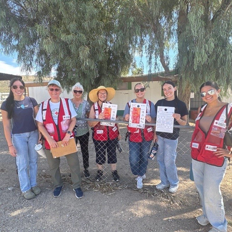 A group of Red Cross volunteers holding up flyers.