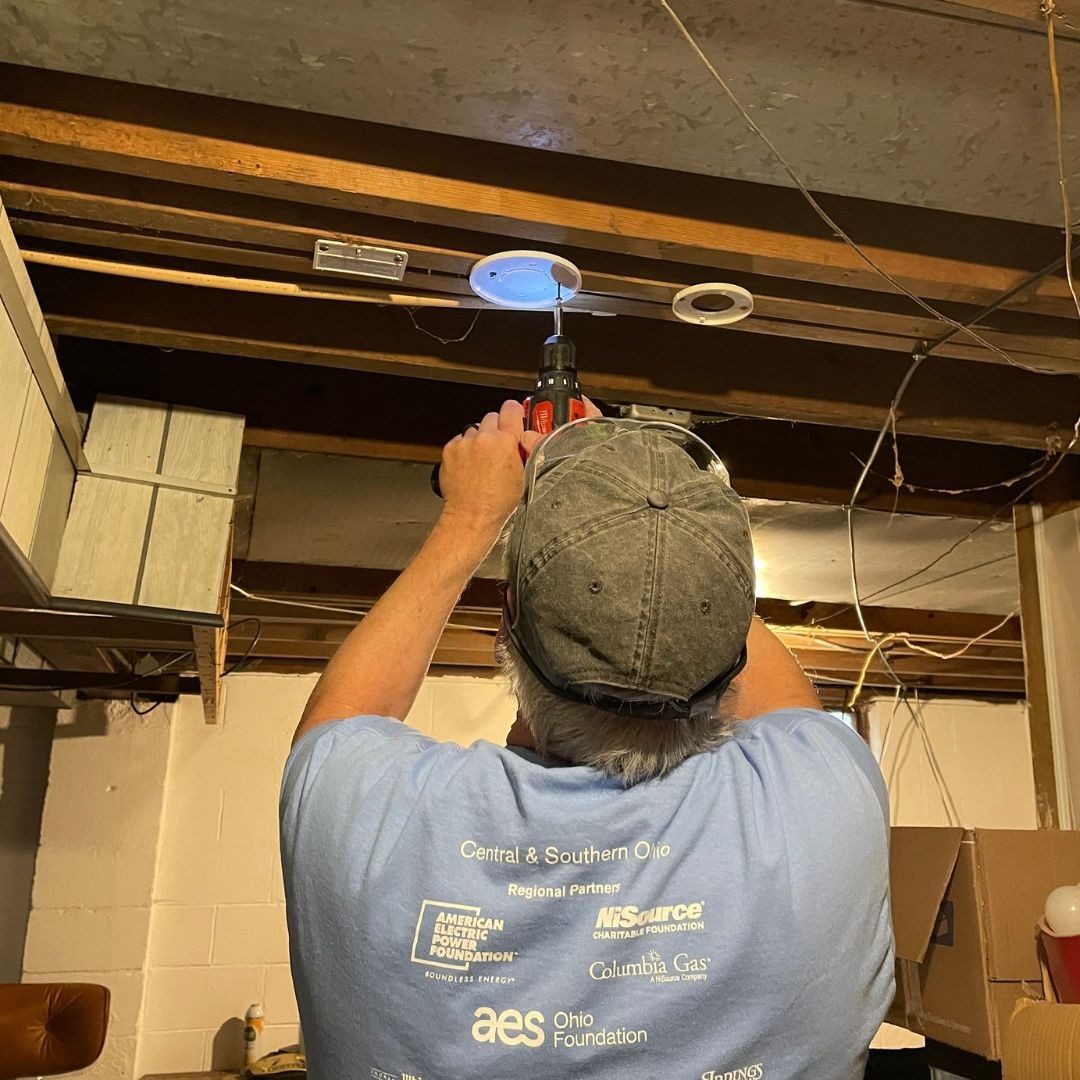 volunteer installing smoke alarm