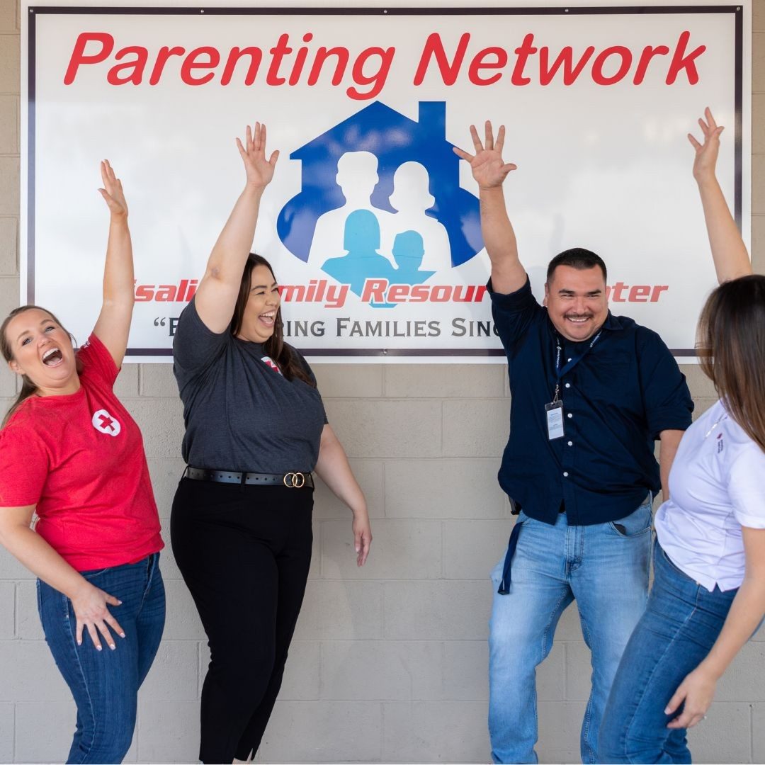 gleeful red crossers in front of parenting network signage