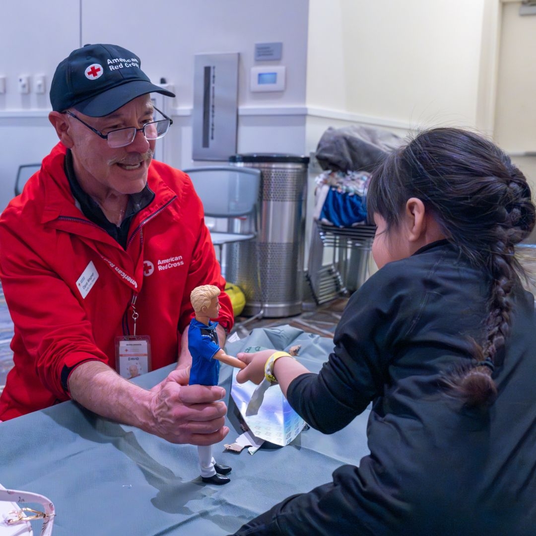 red crosser holding toy for young child