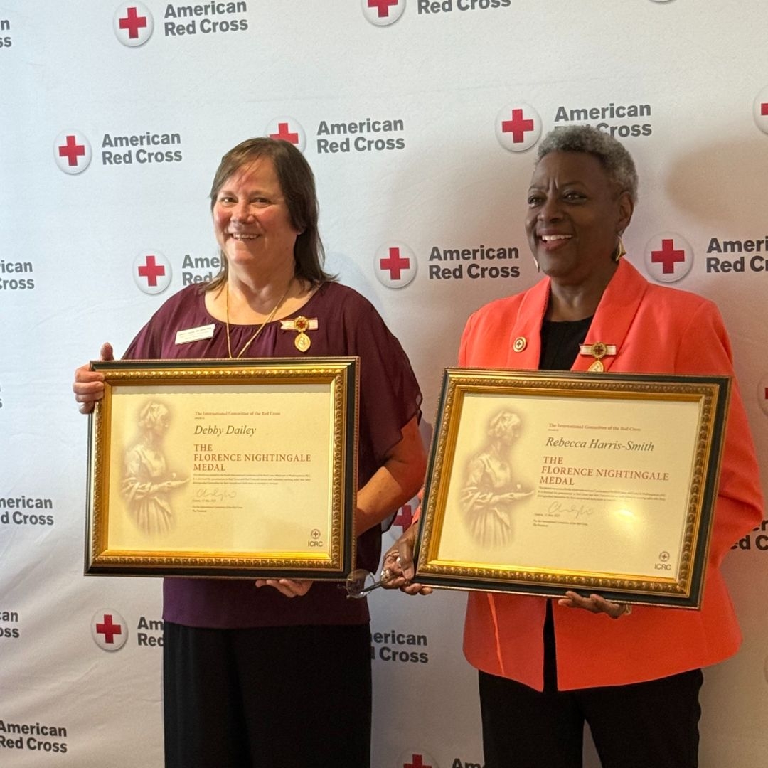 two women holding up awards