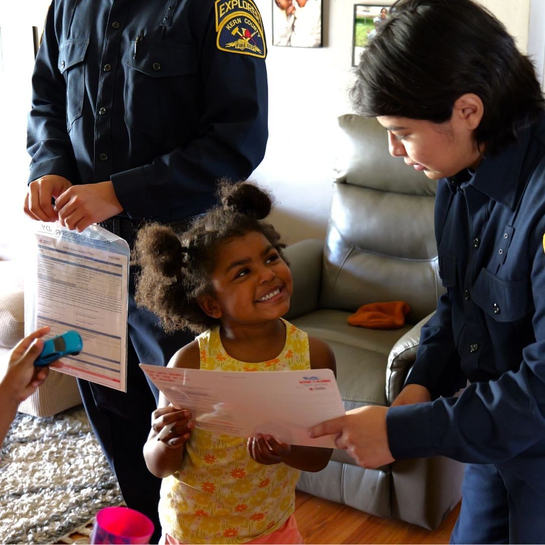 volunteer handing out preparedness packet to small girl