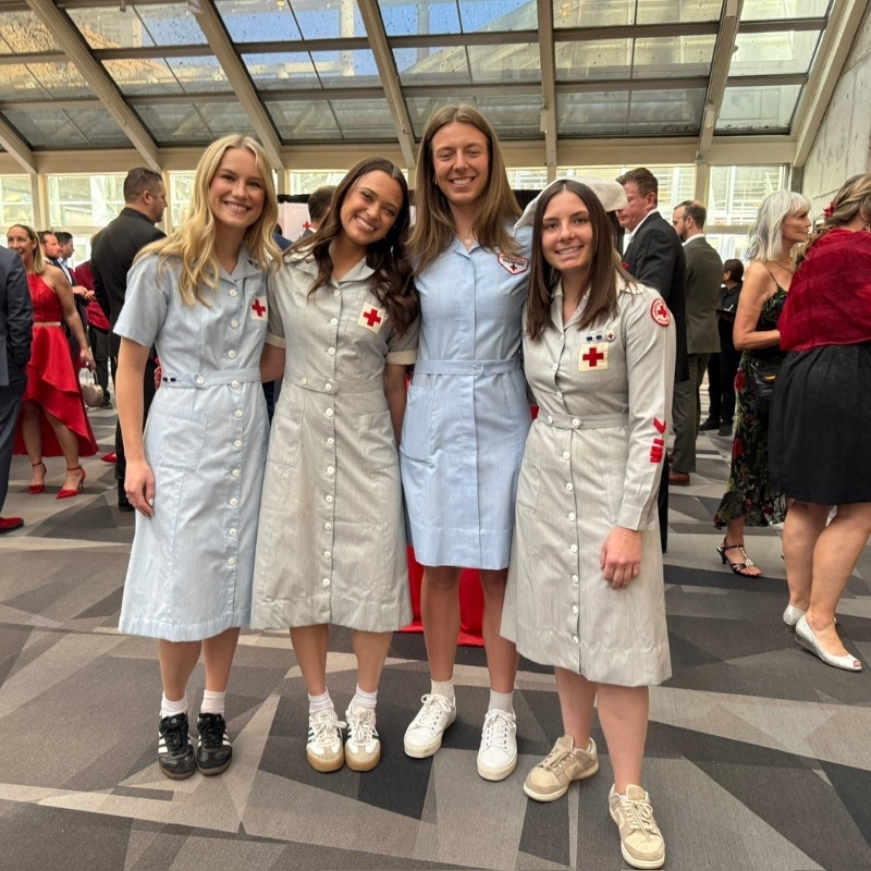 Four Red Cross volunteers dressed in vintage Red Cross nursing uniforms.