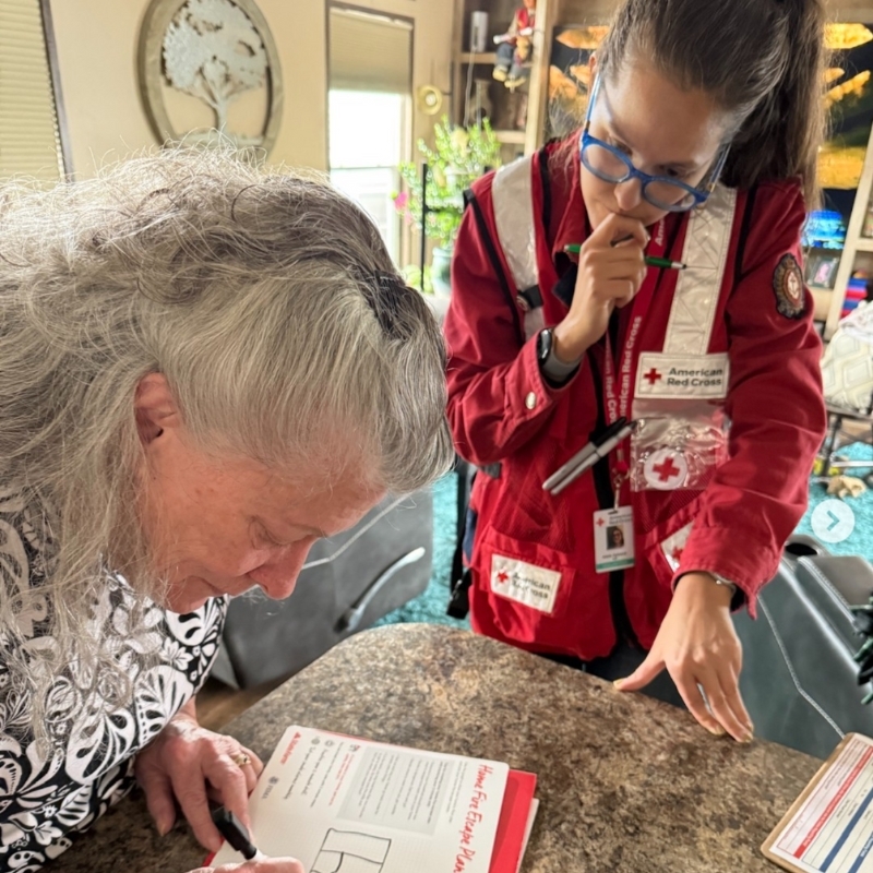 Red Cross volunteer helping client fill out a home fire safety plan. 