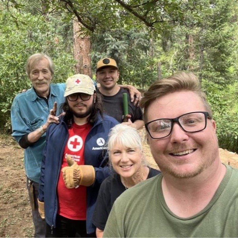 Group of Red Cross volunteers posing for a picture in a park.