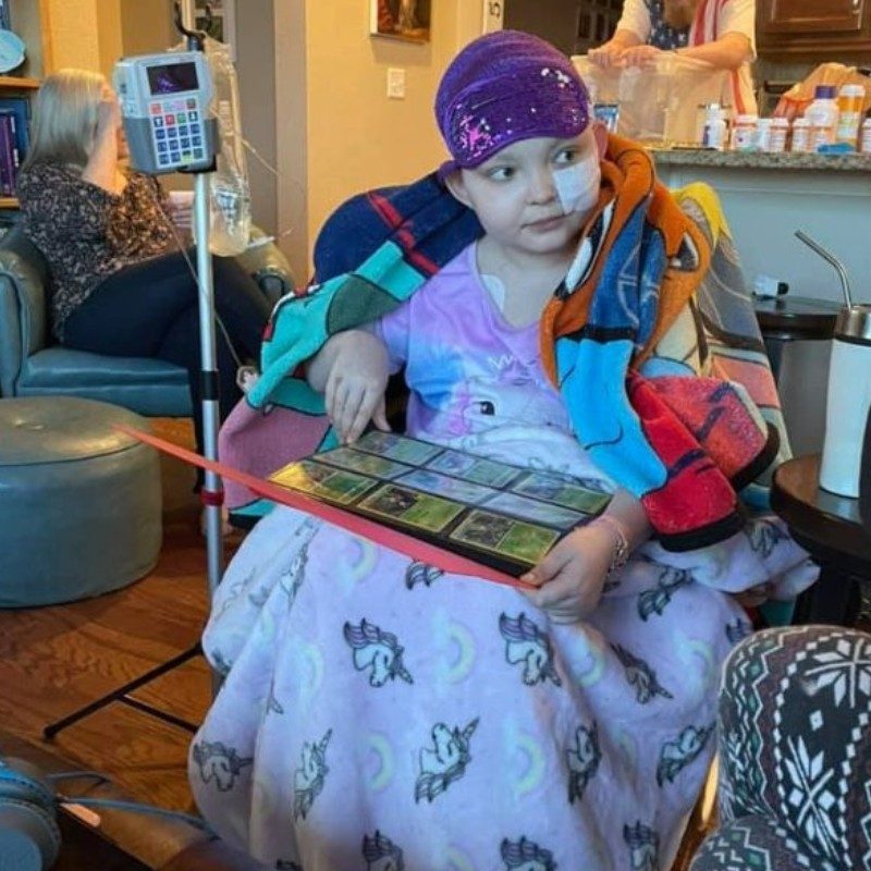 Juno sitting in a chair at home recieving treatment covered in a blanket.