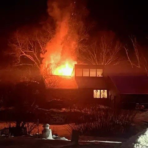 A house on fire at night.