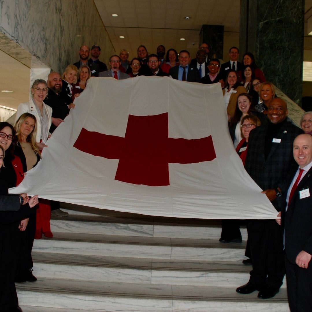 large group off red crossers holding red cross flag
