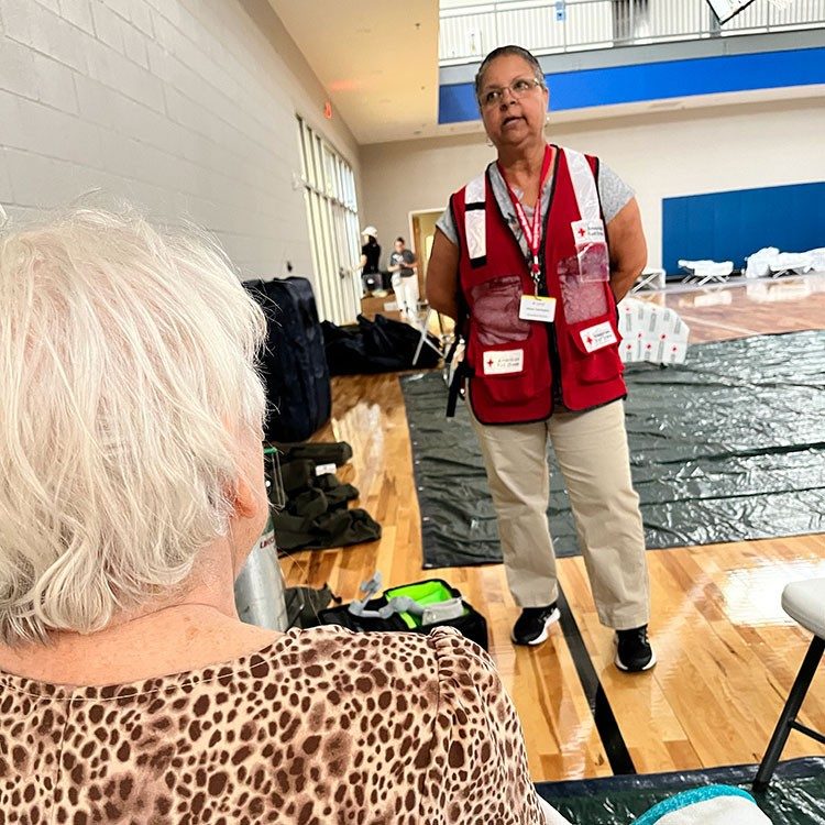 Red Cross volunteer Allean Harrington provides comfort and hope to Peggy Mohr at a Red Cross shelter.