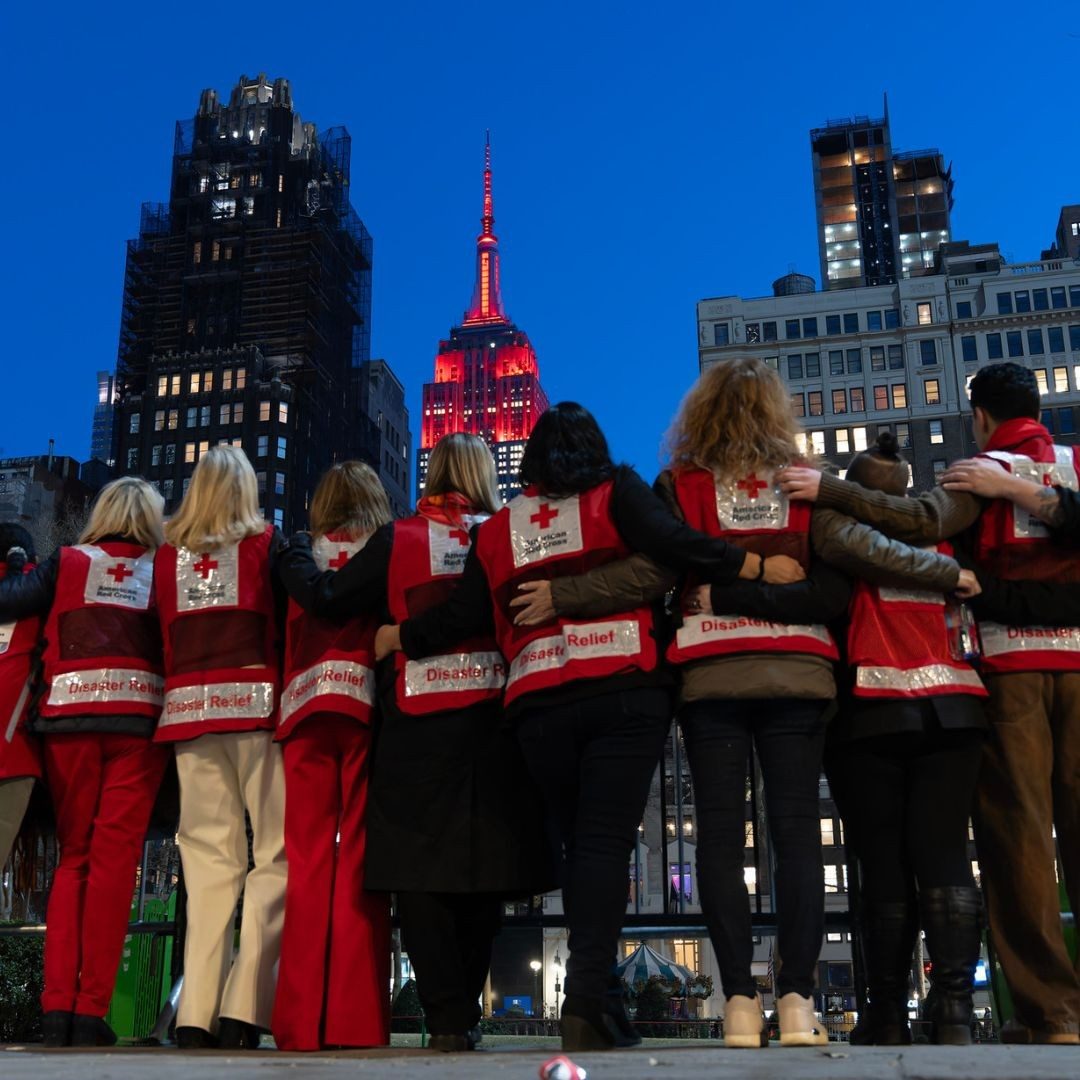 group of red crossers viewing a red-lit skyline