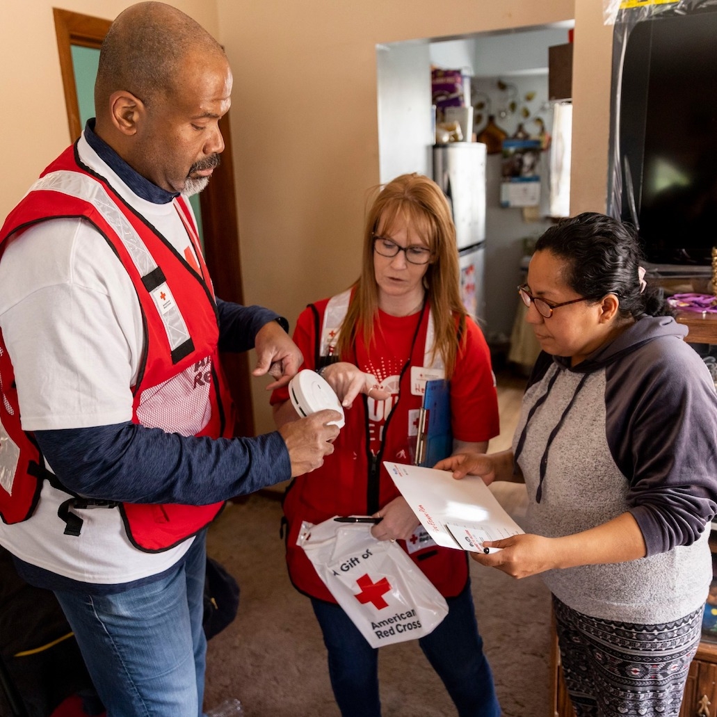 Red Cross volunteers installing a free smoke alarm for a client.