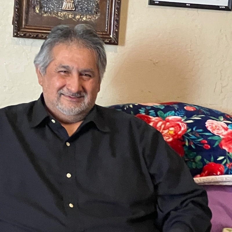 Samuel Hernandez smiling while sitting on a couch.