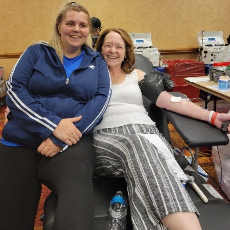 Shandra Sterner donating blood with her sister by her side.