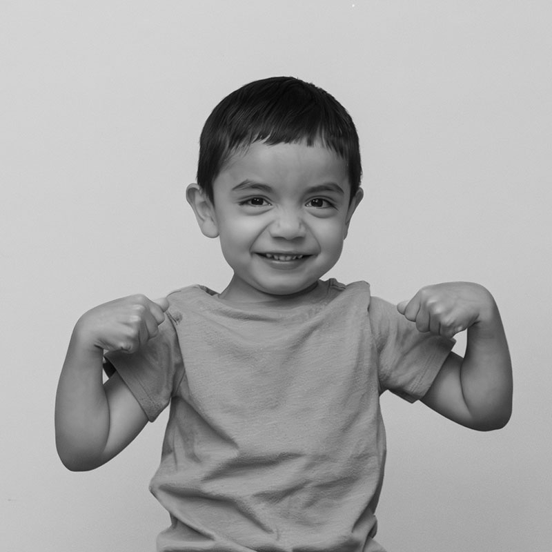 5 year old Diego Villalobos smiling and flexing his arms.