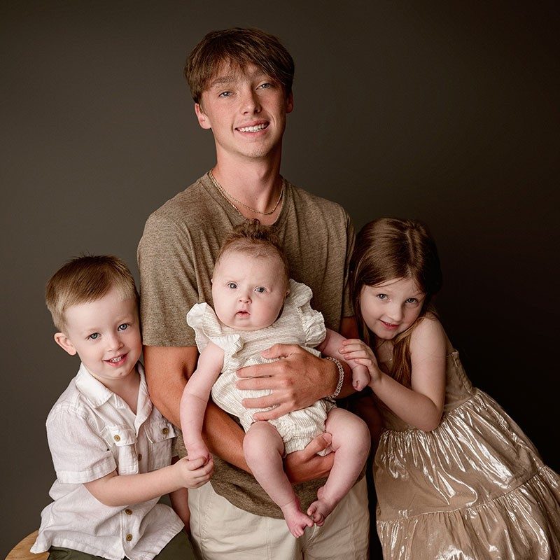 family pic of 4 children with the oldest holding baby Faith Smith.