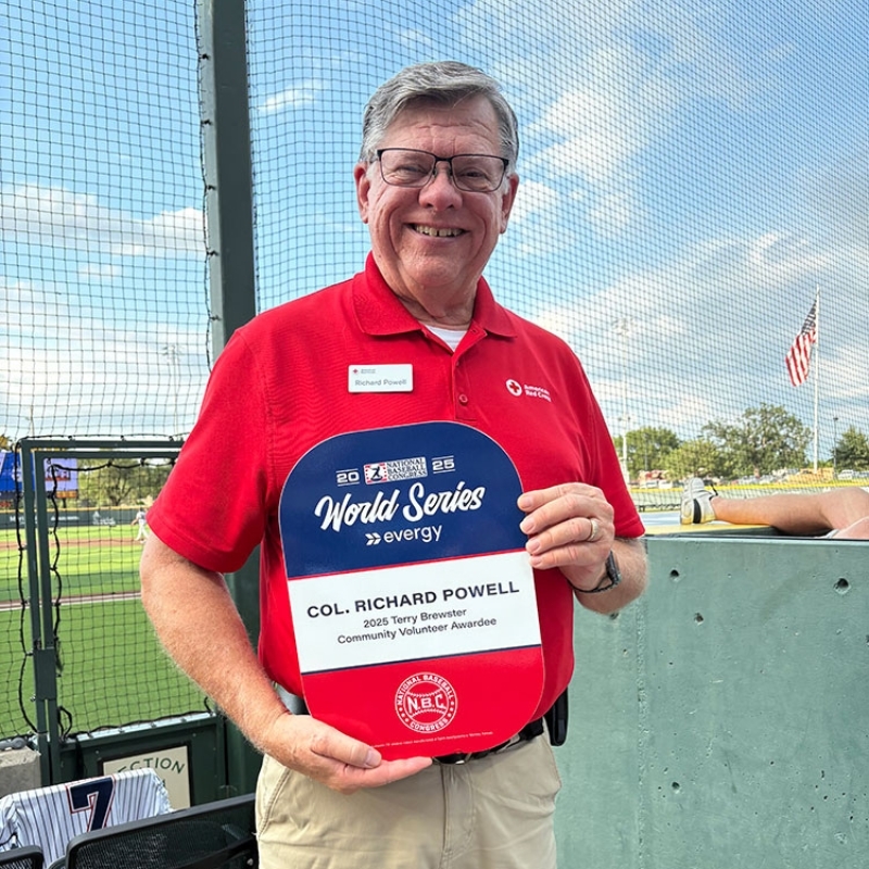 Richard Powell holding an award and smiling.