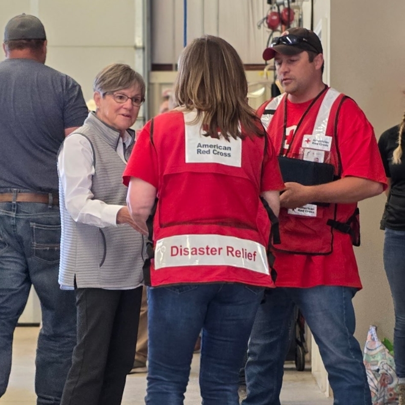 Three Red Cross volunteers standing and talking to each other.