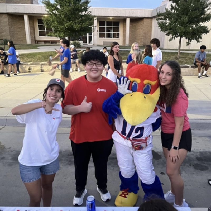 Group of KU students posing with school mascot.