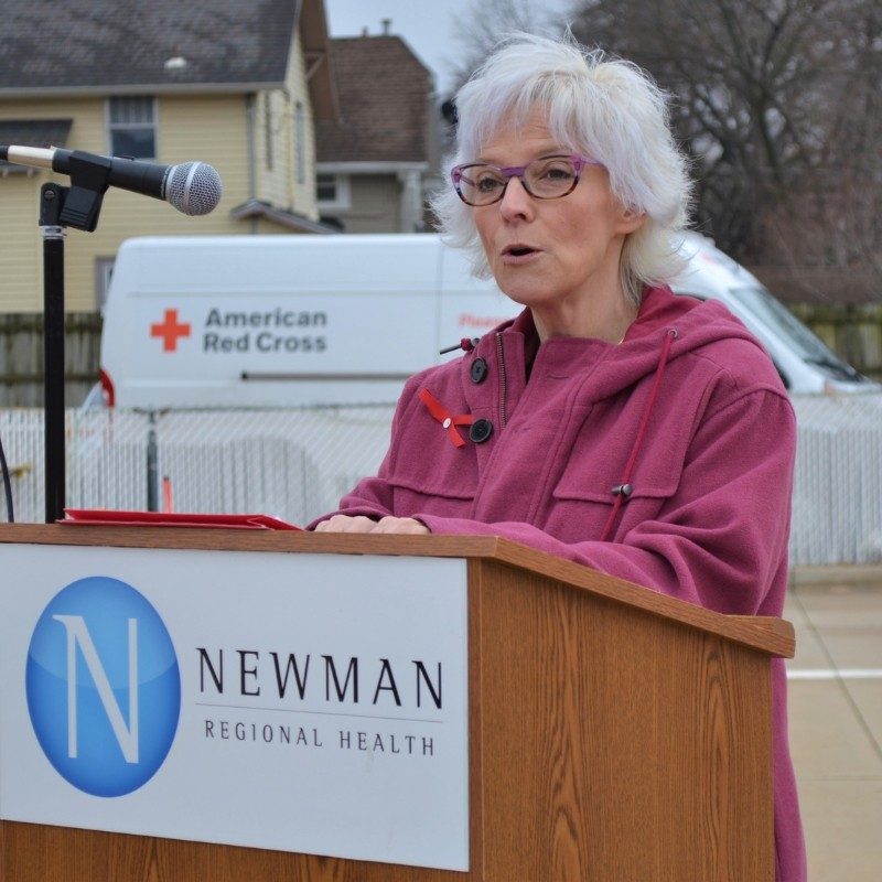 Susan standing at a podium speaking.