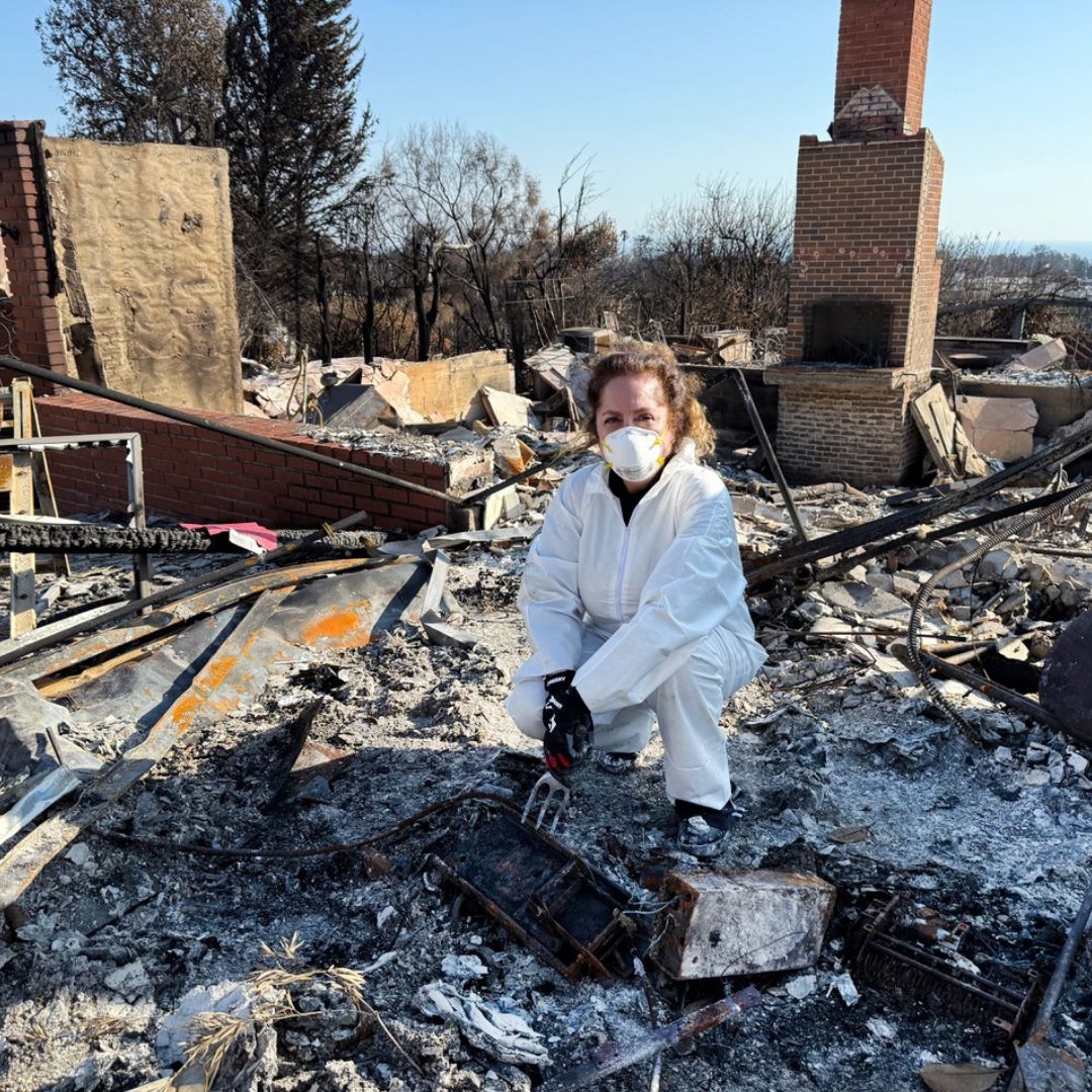 woman at the scene of post-damage house fire