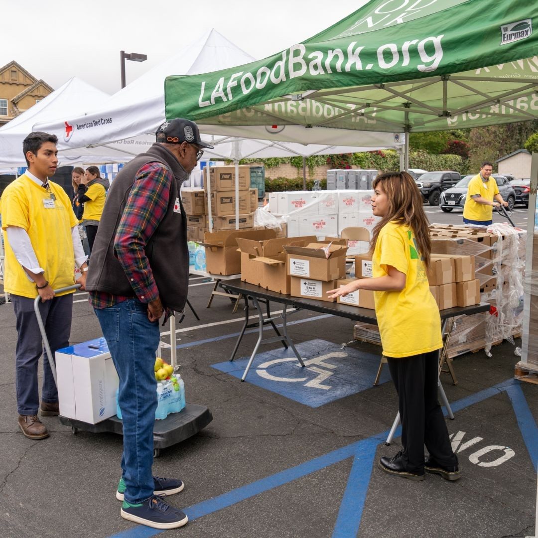 food bank volunteers handing speaking with man