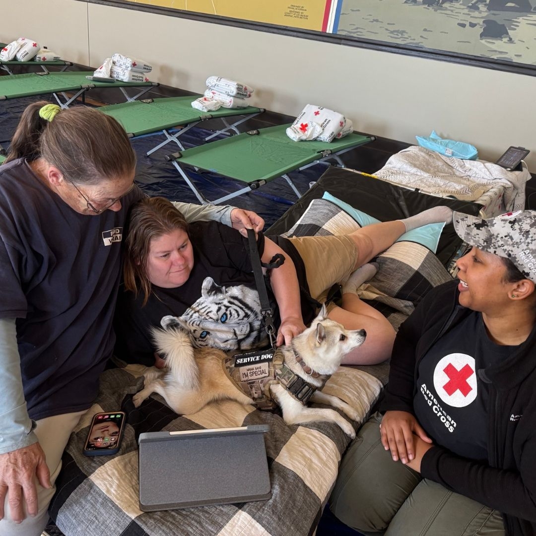veteran with dog speaking to red cross volunteer in shelter