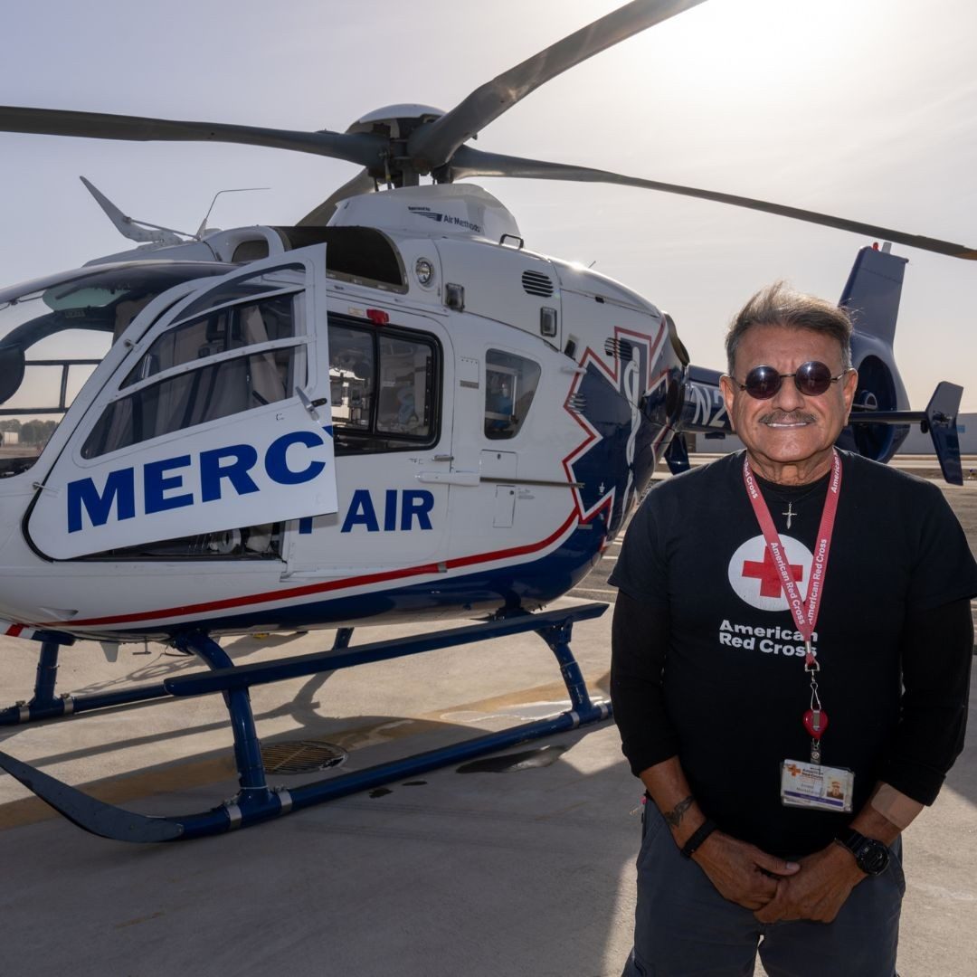 volunteer ernie montelongo in front of helicopter