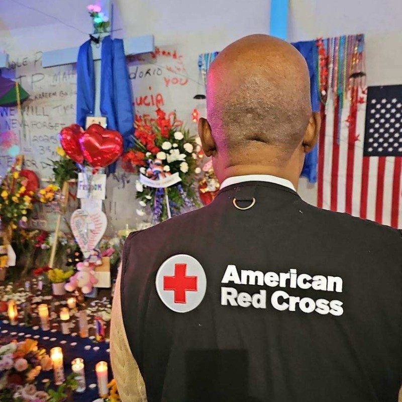 Red Cross volunteer standing facing a vigile.
