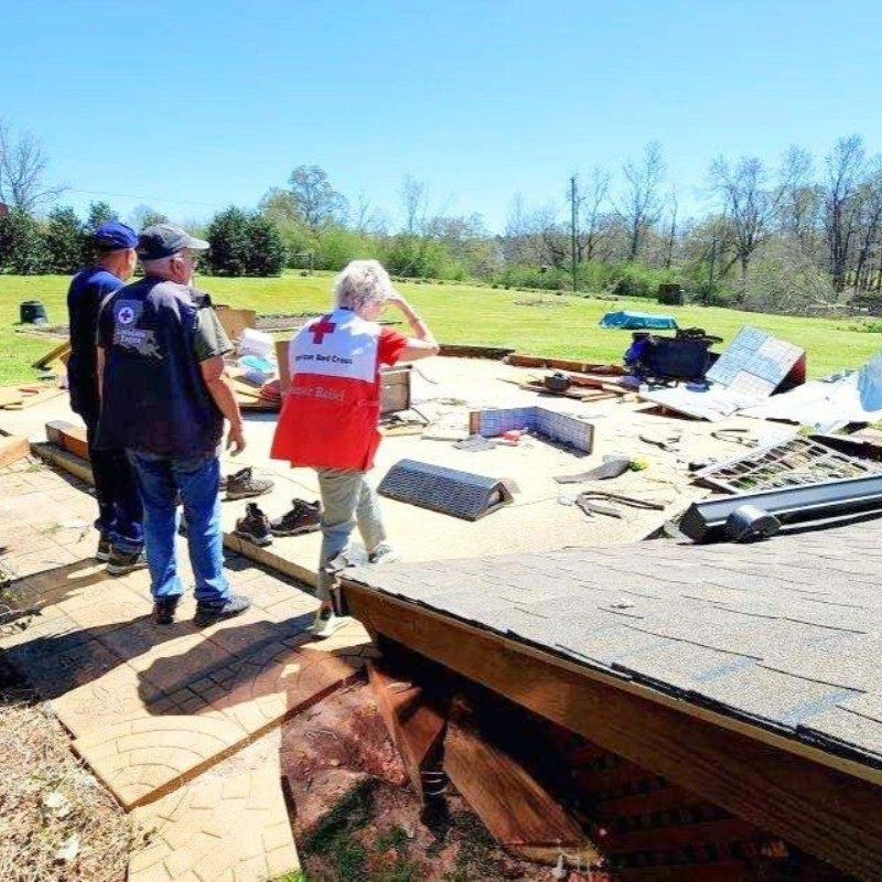 Three Red Cross volunteers surveying tornado damage.