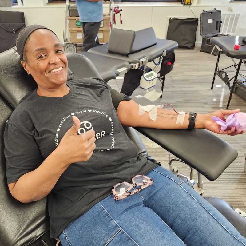 Woman laying on chair giving blood.