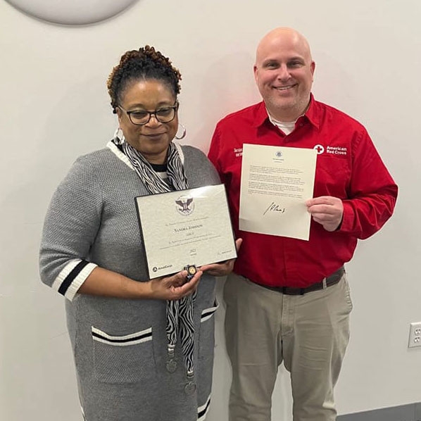 Sandra Johnson and Red Cross employee posing with award.