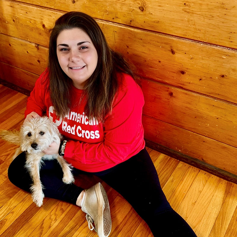 Becca Bohrer with her dog Barley sitting on the floor.