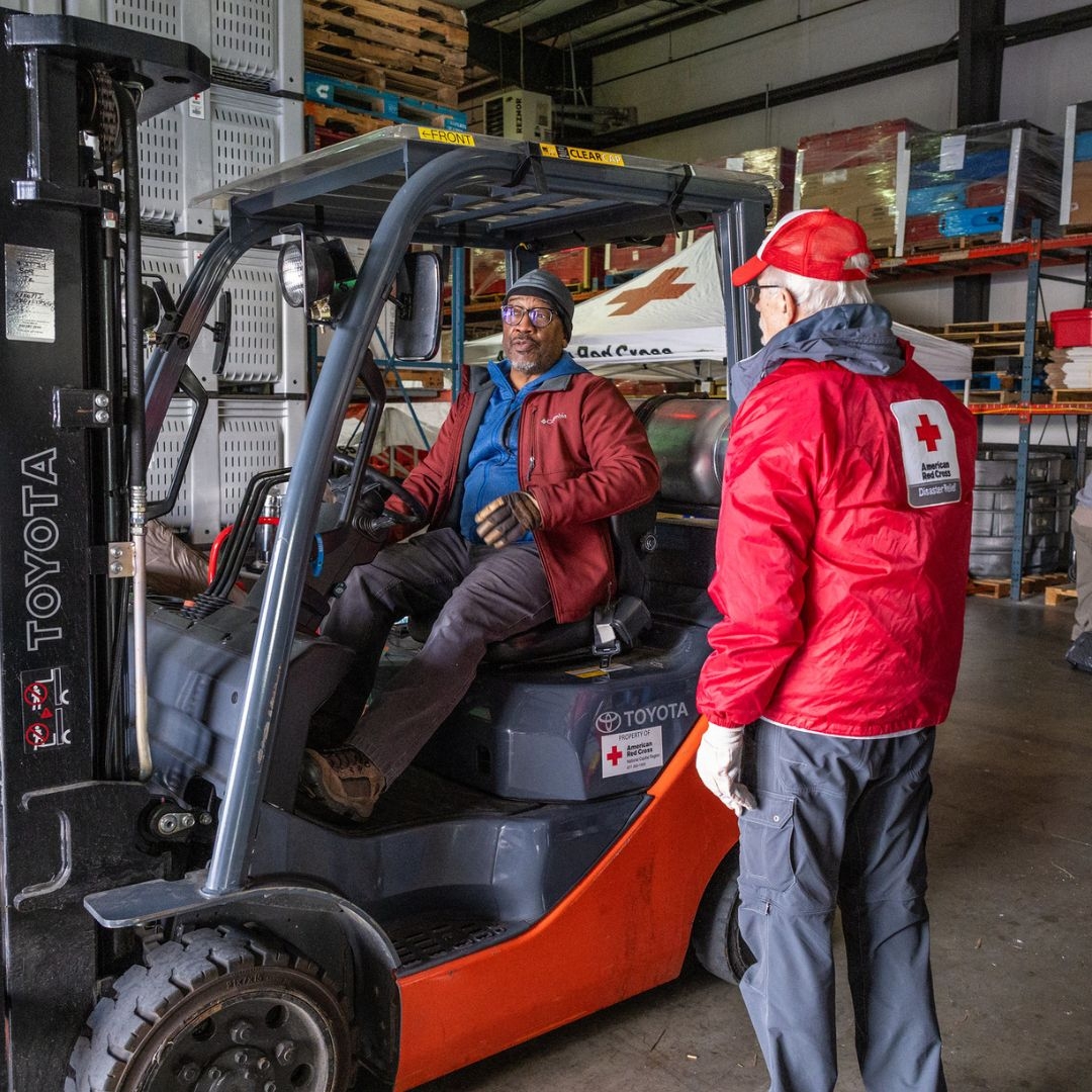 volunteer speaking with man on forklift