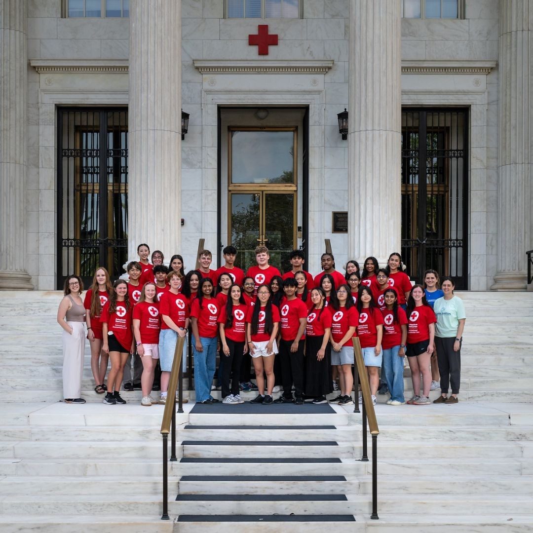 group of youth volunteers on the steps of the red cross headquarters