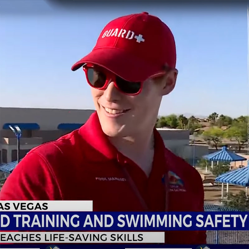 Lifegaurd wearing hat and sunglasses, being interviewed on a news station.