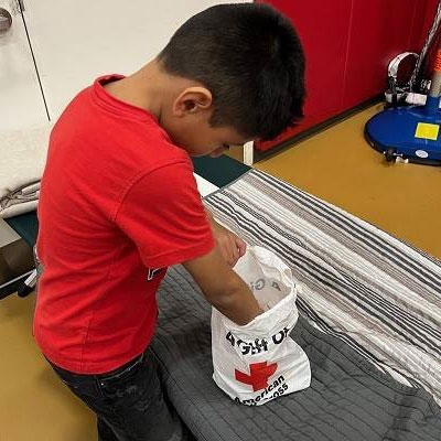 Young boy looks through a Red Cross supplies bag.