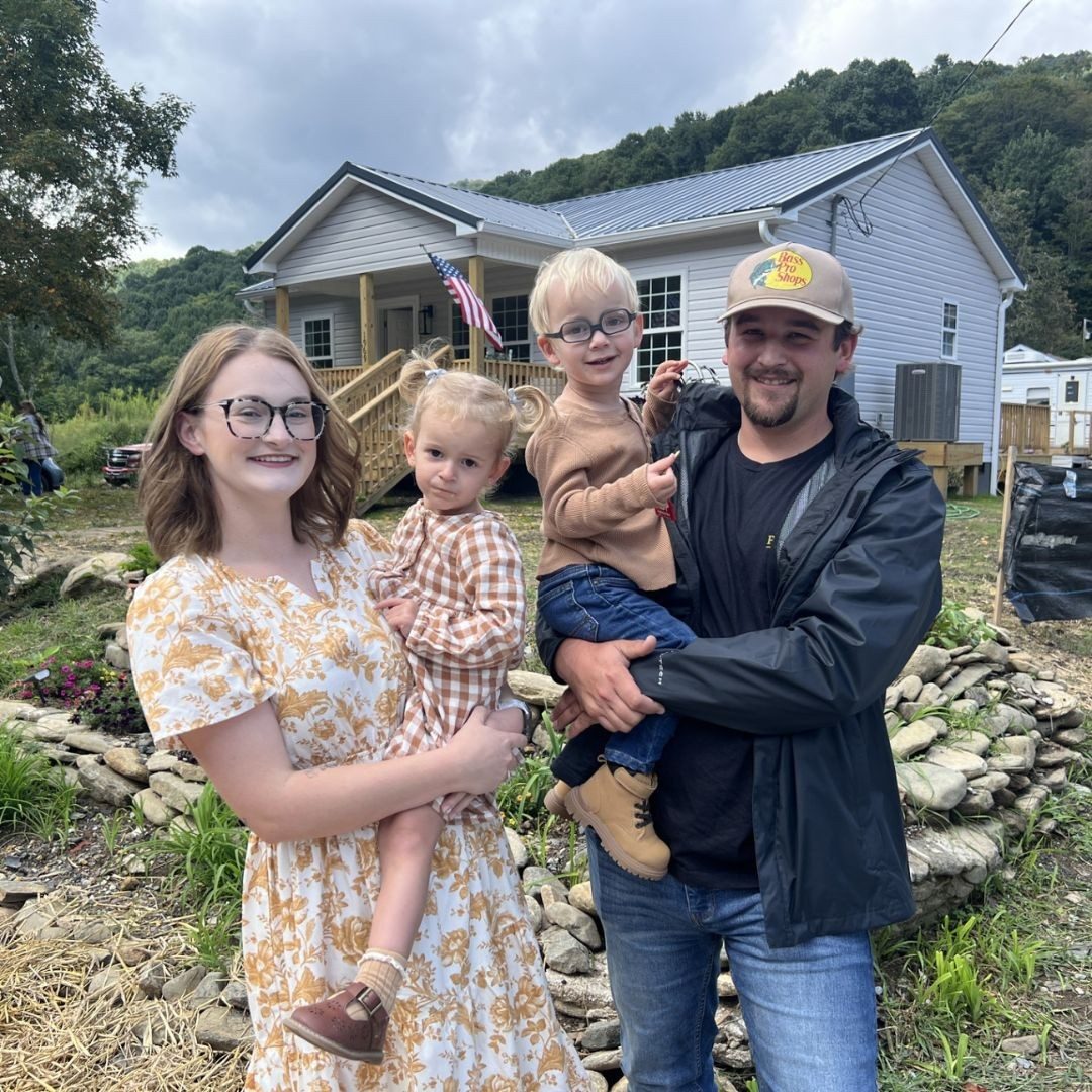 happy family of four outside of home